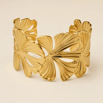Bracelete largo dourado com folhas tropicais