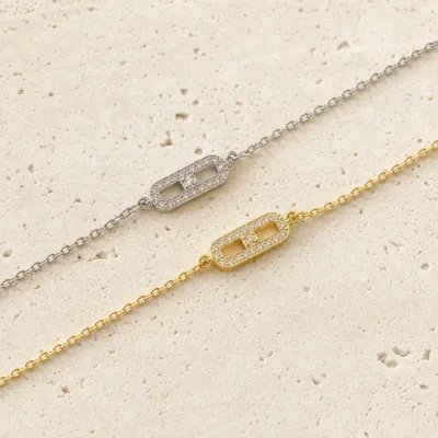 Detalhe da pulseira em aço dourado com placa brilhante
