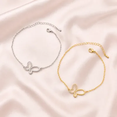 Pulseiras de borboleta prateada e dourada em composição editorial