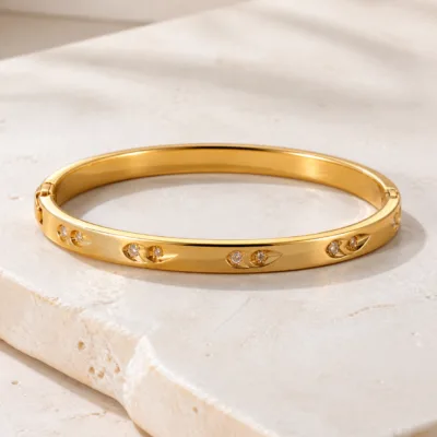 Bracelete dourado com cristais sobre pedra clara