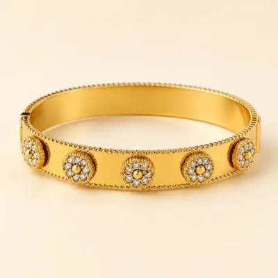 Bracelete dourado largo com medalhões florais e cristais
