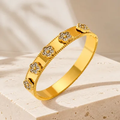 Bracelete dourado com medalhões sobre pedra clara
