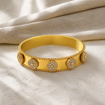 Bracelete dourado largo sobre linho claro