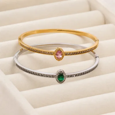 Braceletes dourado e prateado com pedra oval em expositor de joalharia