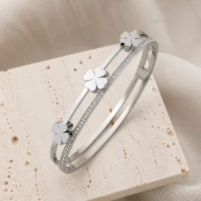 Bracelete prateado com trevos sobre pedra clara