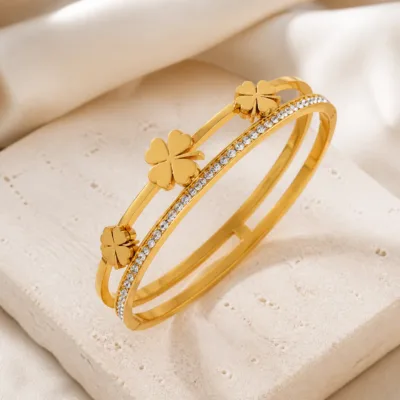 Bracelete dourado com trevos sobre pedra clara
