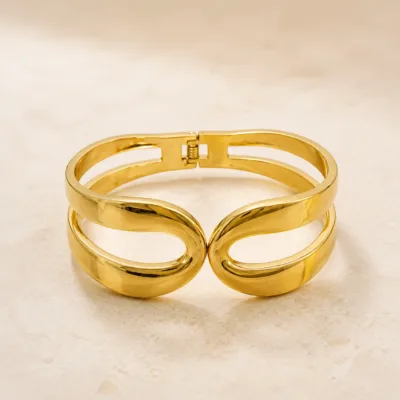 Bracelete dourado largo com design frontal de laço duplo