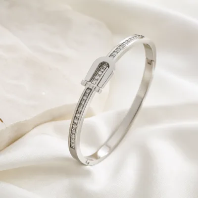 Bracelete prateado com cristais sobre tecido claro