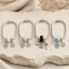 Quatro pulseiras de charms em aço com contas branca, rosa, preta e azul