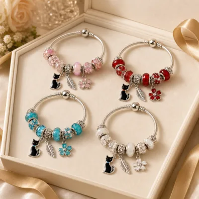 Quatro pulseiras de charms com gato numa caixa de joalharia
