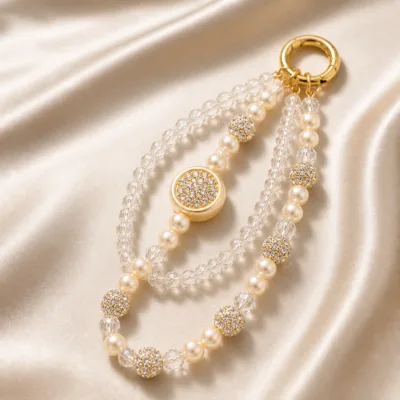 Pulseira dourada com pérolas e cristais sobre cetim champanhe