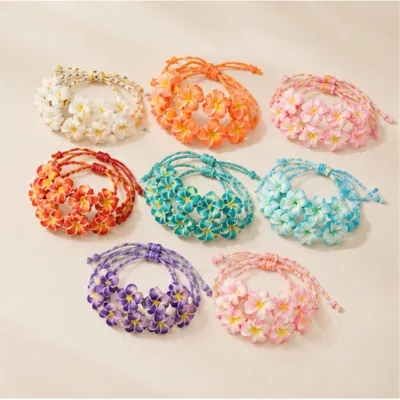 Pulseiras com flores tropicais organizadas por cor numa composição plana