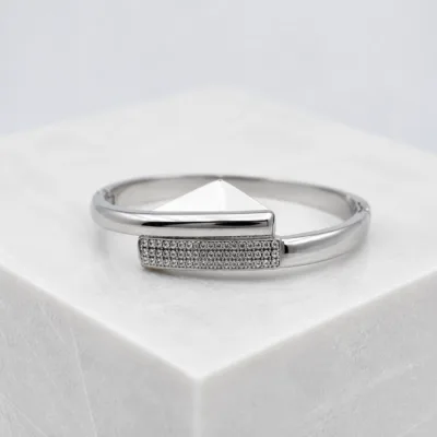 Bracelete prateado com cristais sobre pedestal claro