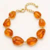 Variante A laranja da pulseira dourada com pedras irregulares