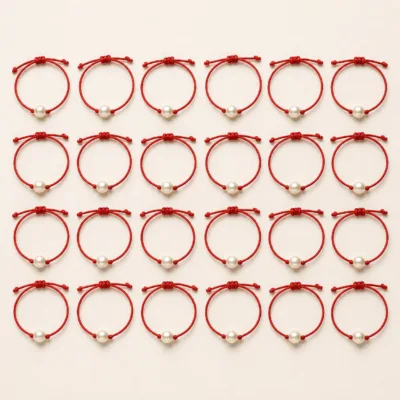 Vinte e quatro pulseiras de cordão vermelho dispostas em quatro filas