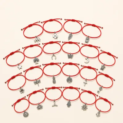 Detalhe dos amuletos prateados e do cordão vermelho ajustável