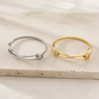 Gold and silver double-band crystal charm bangles shown side by side
