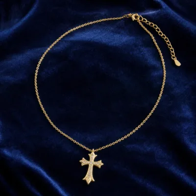 Colar dourado com cruz em composição editorial azul