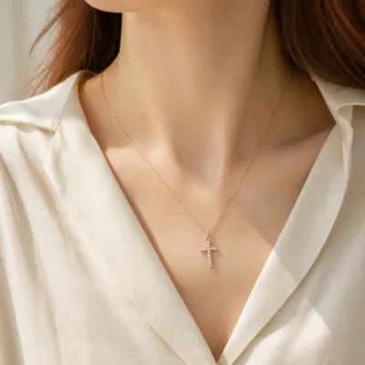 Gold-tone crystal cross necklace 85587 worn with a cream blouse