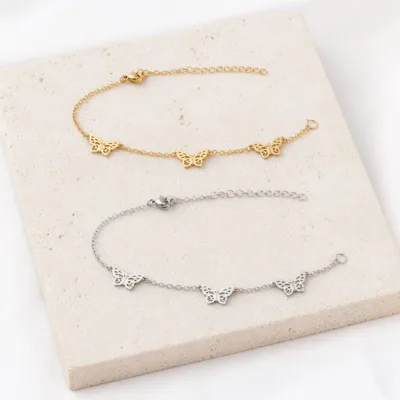 Comparação das pulseiras dourada e prateada com borboletas
