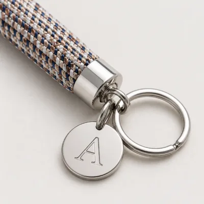 Detalhe da corda tubular, medalha de letra e argola metálica
