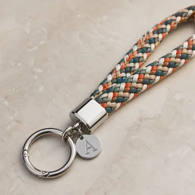 Detalhe da corda tubular, medalha de letra e argola metálica