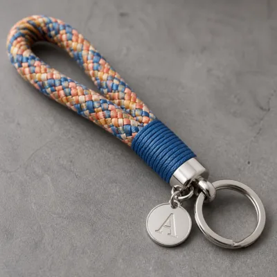 Detalhe da corda tubular, medalha de letra e argola metálica