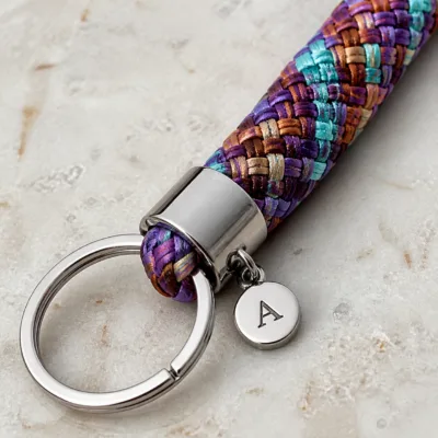 Detalhe da corda tubular, medalha de letra e argola metálica