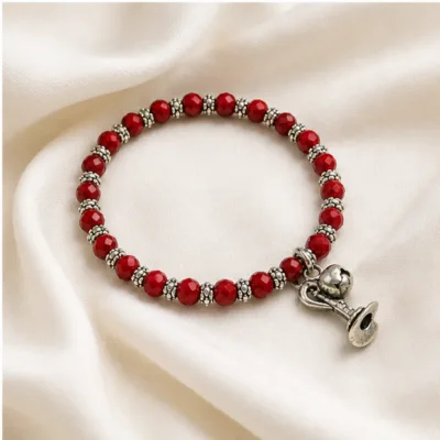 Pulseira vermelha de cristais com coração e taça sobre tecido claro