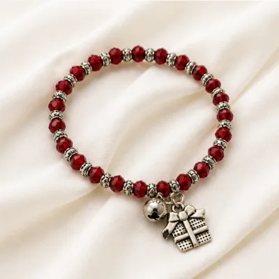 Pulseira vermelha de cristais com presente sobre tecido claro