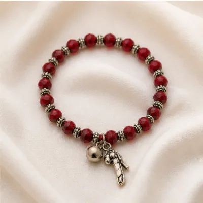 Pulseira vermelha de cristais com sapato sobre tecido claro