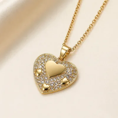 Pormenor do colar dourado de coração com zircónias