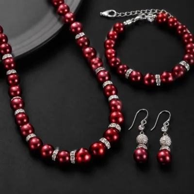 Detalhe das pérolas vermelho-escuras e zircónias