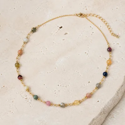 Detalhe do colar dourado com pedras naturais multicoloridas