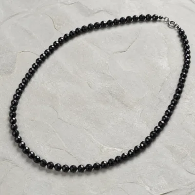 Colar de cristal preto sobre pedra clara