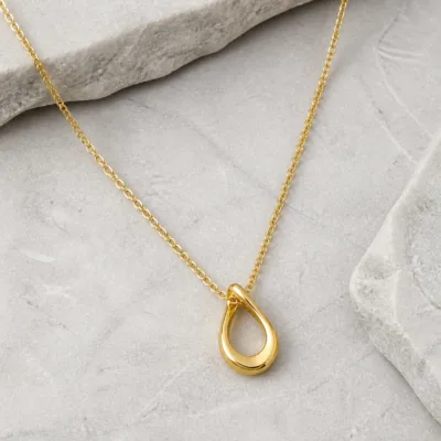 Colar dourado sobre pedra clara