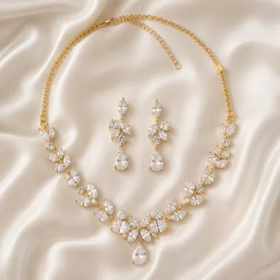 Conjunto dourado de colar e brincos sobre tecido claro
