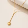 Colar dourado com barra e pendente de coração