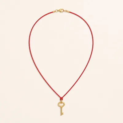 Colar de cordão vermelho com chave dourada