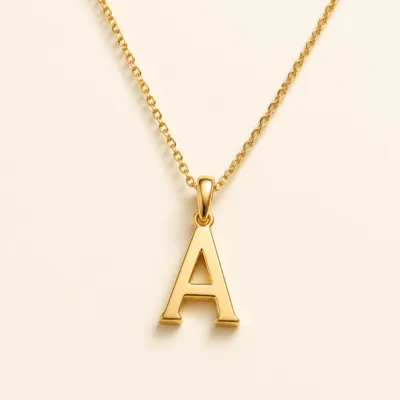 Colar dourado em aço com pendente de letra
